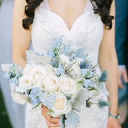 Bride holding a white and pale blue bouquet