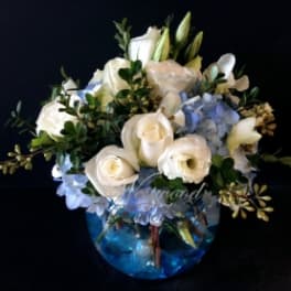 White roses and blue hydrangeas in a blue glass vase