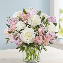 Pink and white bouquet of roses and alstroemeria in a clear glass vase