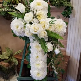 White roses and chrysanthemums arranged in a cross-shaped standing spray