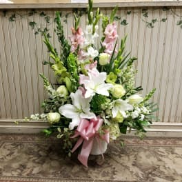 Tall floral arrangement with white lilies and pink gladiolus in a vase