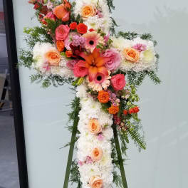 Cross-shaped floral standing spray with white blooms and peach, pink, and orange flowers