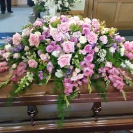Large pink and white floral casket spray on a coffin