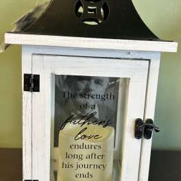 White memorial lantern with a candle and father’s love message