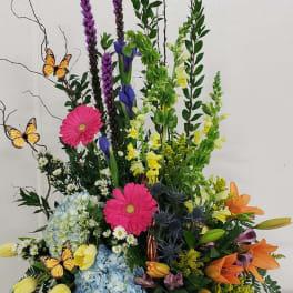 Tall mixed flower basket with butterflies and bright blooms