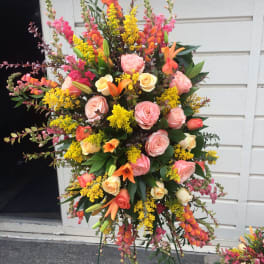 Tall standing floral spray with pink roses, orange lilies, and yellow filler flowers