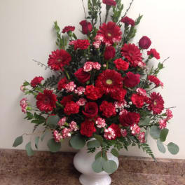 Red roses and gerbera daisies in a white vase