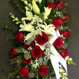 Red roses and white lilies arranged with a white ribbon