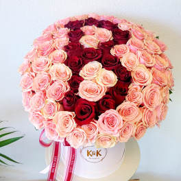 Round bouquet of pink and red roses in a white hat box