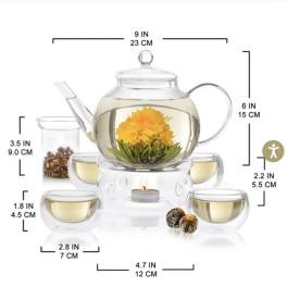 Glass teapot with a yellow flower blooming inside, surrounded by matching cups