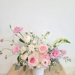 Pink and white floral arrangement in a white vase