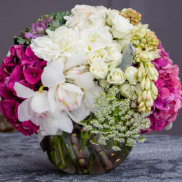 Bouquet of white and magenta flowers in a clear glass vase