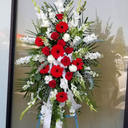 Large standing floral spray with red and white flowers on an easel