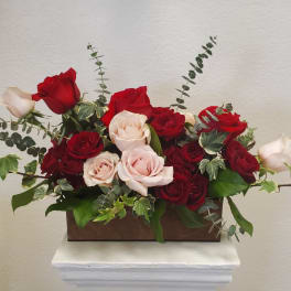 Red and blush roses arranged in a rectangular wooden box