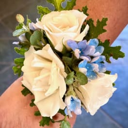 Small wrist corsage with white roses and blue flowers