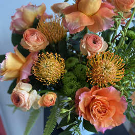 Orange and peach bouquet with roses and pincushion blooms
