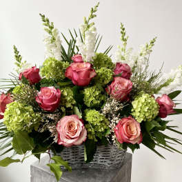 Pink roses and green hydrangeas in a wicker basket