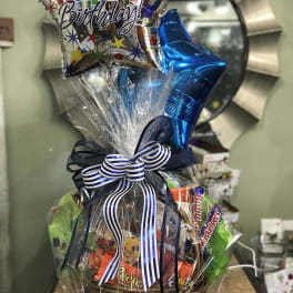 Birthday gift basket with balloons, candy, and ribbon