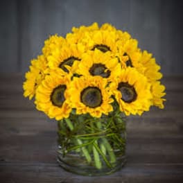 Yellow sunflowers arranged in a clear glass vase