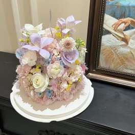 Pastel floral arrangement on a white round base