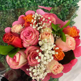 Bouquet of pink, peach, and orange roses with white baby's breath
