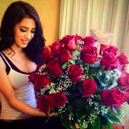 Woman holding a large bouquet of red roses