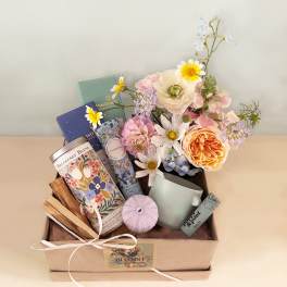 Gift box with pastel flowers, tea tins, and a mug