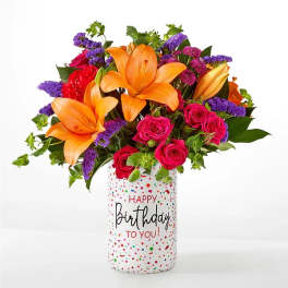 Orange lilies and pink roses in a birthday vase