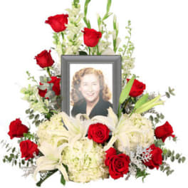 Memorial floral frame with red roses, white lilies, and a portrait