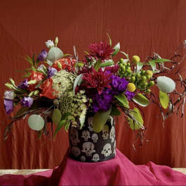 Colorful mixed bouquet in a black skull-patterned container