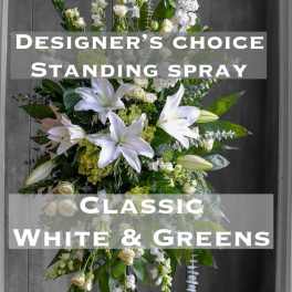 White and green standing spray with lilies and roses on a stand