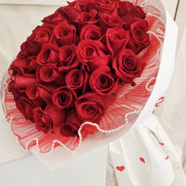 Bouquet of red roses wrapped in white and red paper