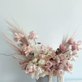 Blush roses and pale pink flowers in a gray vase