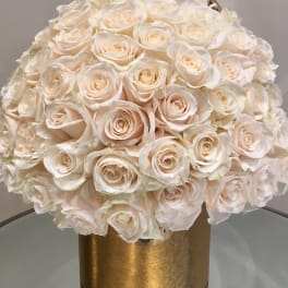 Round bouquet of ivory roses in a gold box