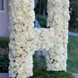 Large floral letter H covered in cream roses