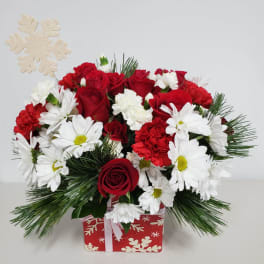Red roses and white daisies in a holiday gift box with a snowflake pick