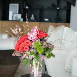 Pink and red floral arrangement in a clear glass vase