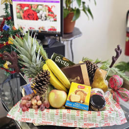 Holiday gift basket with fruit, chocolates, and a pineapple centerpiece