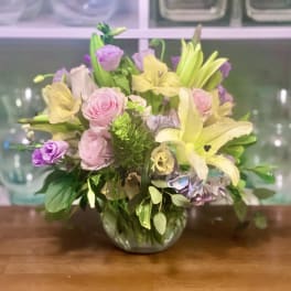 Mixed pastel bouquet in a glass vase with lilies and roses
