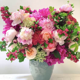 Pink and peach floral arrangement in a blue vase