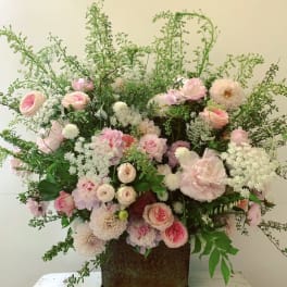 Large pink and white floral arrangement in a decorative container
