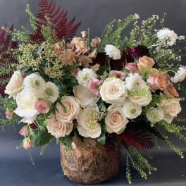 Large bouquet of blush and white roses with mixed blooms in a textured vase