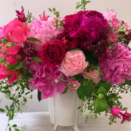 Pink and magenta floral arrangement in a white vase