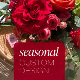 Red and pink rose bouquet with eucalyptus in a basket