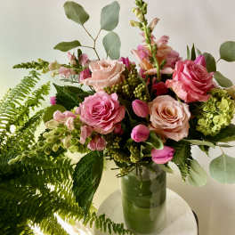 Pink roses and snapdragons in a green glass vase