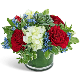 Red roses and white hydrangeas in a glass vase with blue accents
