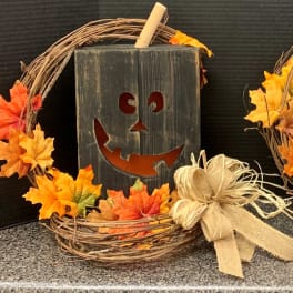 Halloween wreath with orange leaves and a jack-o'-lantern sign
