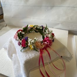 Floral crown with pink, yellow, purple, and white flowers and ribbon streamers