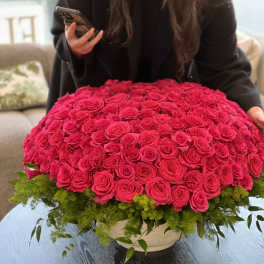 Large dome of hot pink roses in a low white container