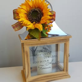 Sunflower arrangement on a wooden memorial lantern with a candle inside